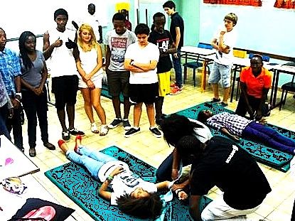 Élèves apprenant à examiner une victime lors d'un atelier de premiers secours