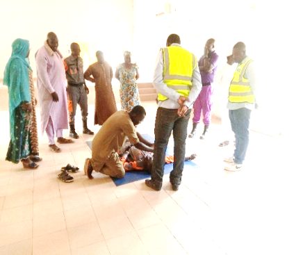 Stagiaire moniteur démontrant un geste de secours devant le groupe